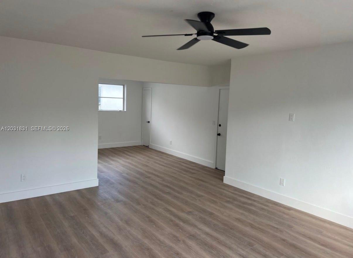 An interior room features light wood-look flooring, white walls, and a black ceiling fan — 7730 Byron Ave # 4, Miami Beach FL 33141, MIAMI BEACH, FL