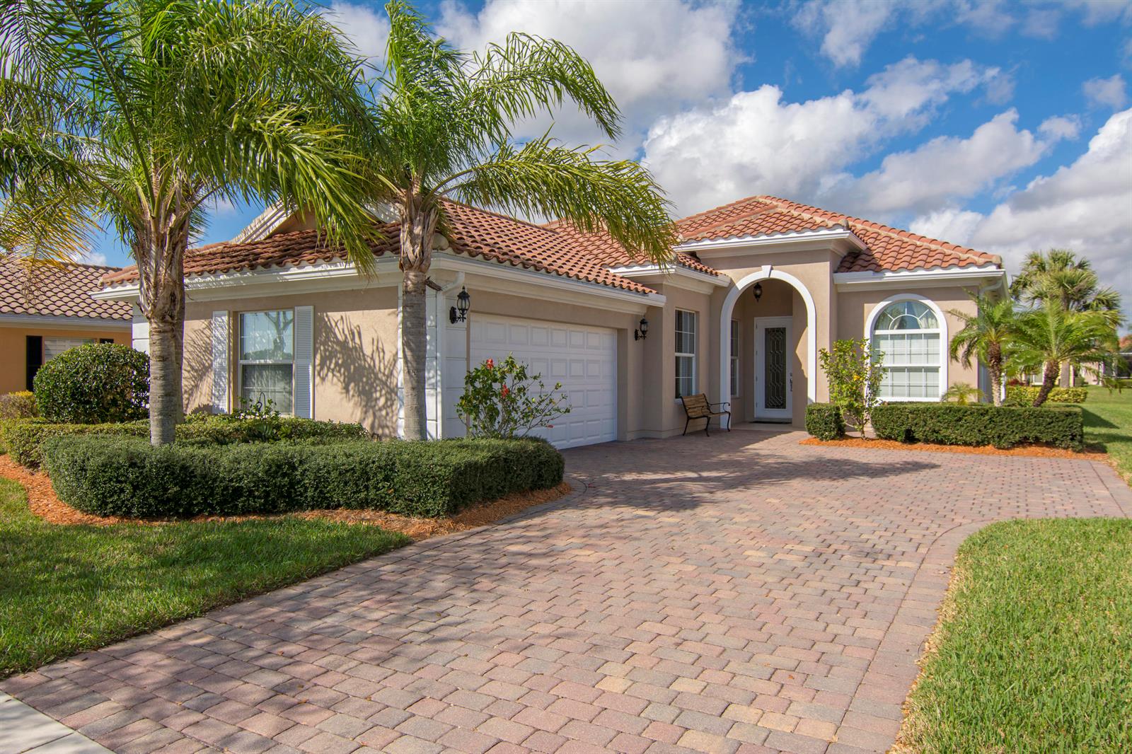 A single-story house with a tiled roof, brick paver driveway, and palm trees in the yard — 5254 Eleuthra Circle, Vero Beach FL 32967, VERO BEACH, FL