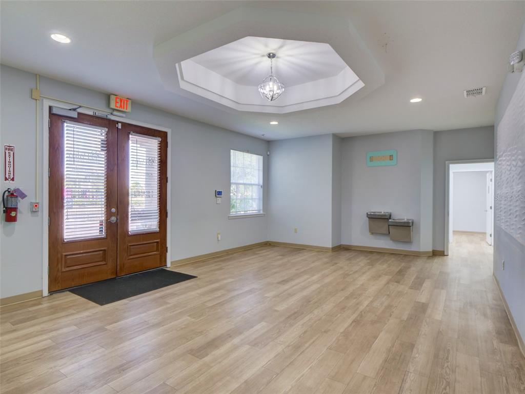 A bright lobby features wood-look flooring, a double-door entrance, and a recessed octagonal ceiling light — 733 S GOLDENROD ROAD, ORLANDO, FL