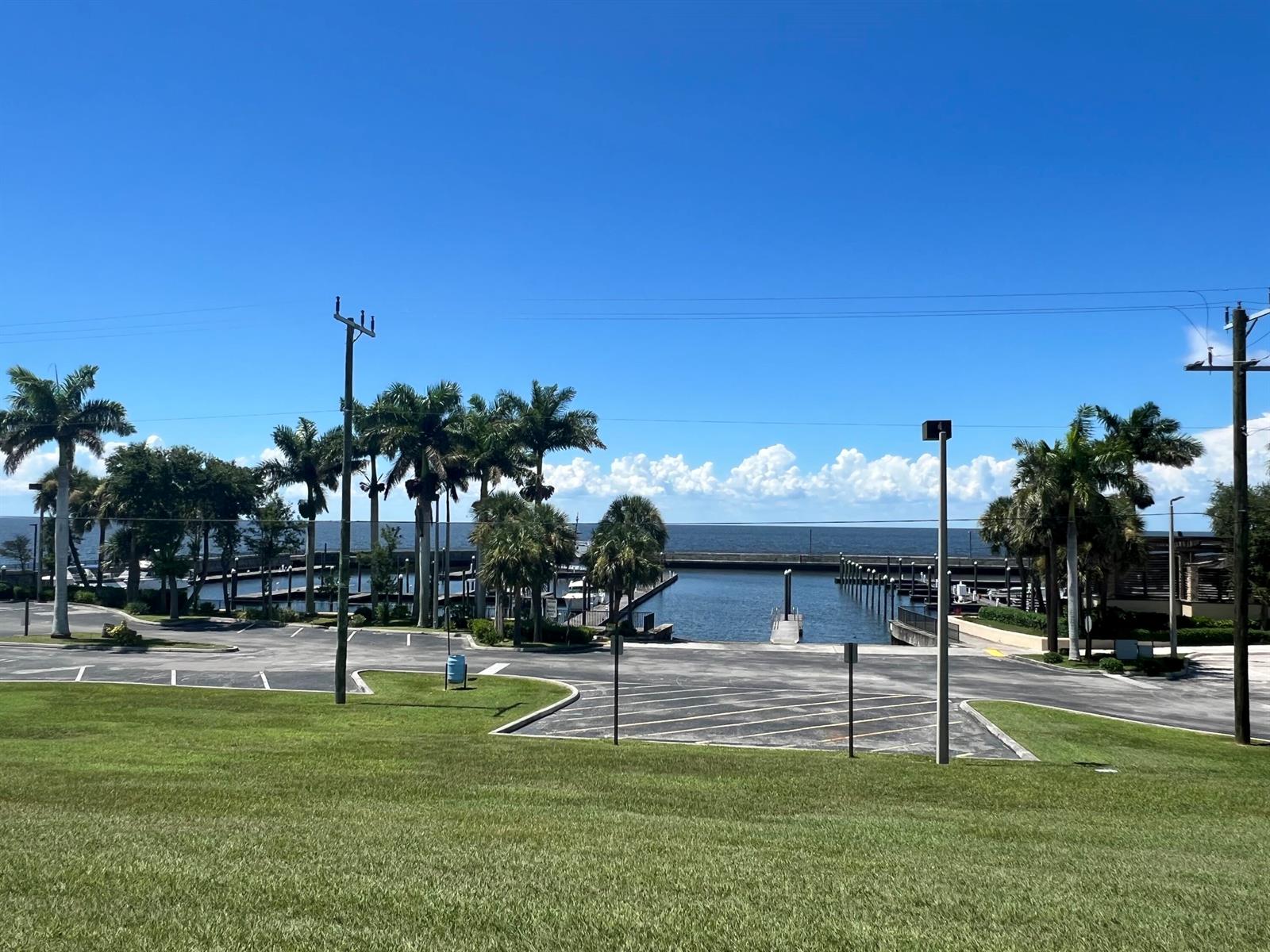 A view of a boat basin and parking lot framed by palm trees under blue skies — 197 W Main Street, Pahokee FL 33476, PAHOKEE, FL