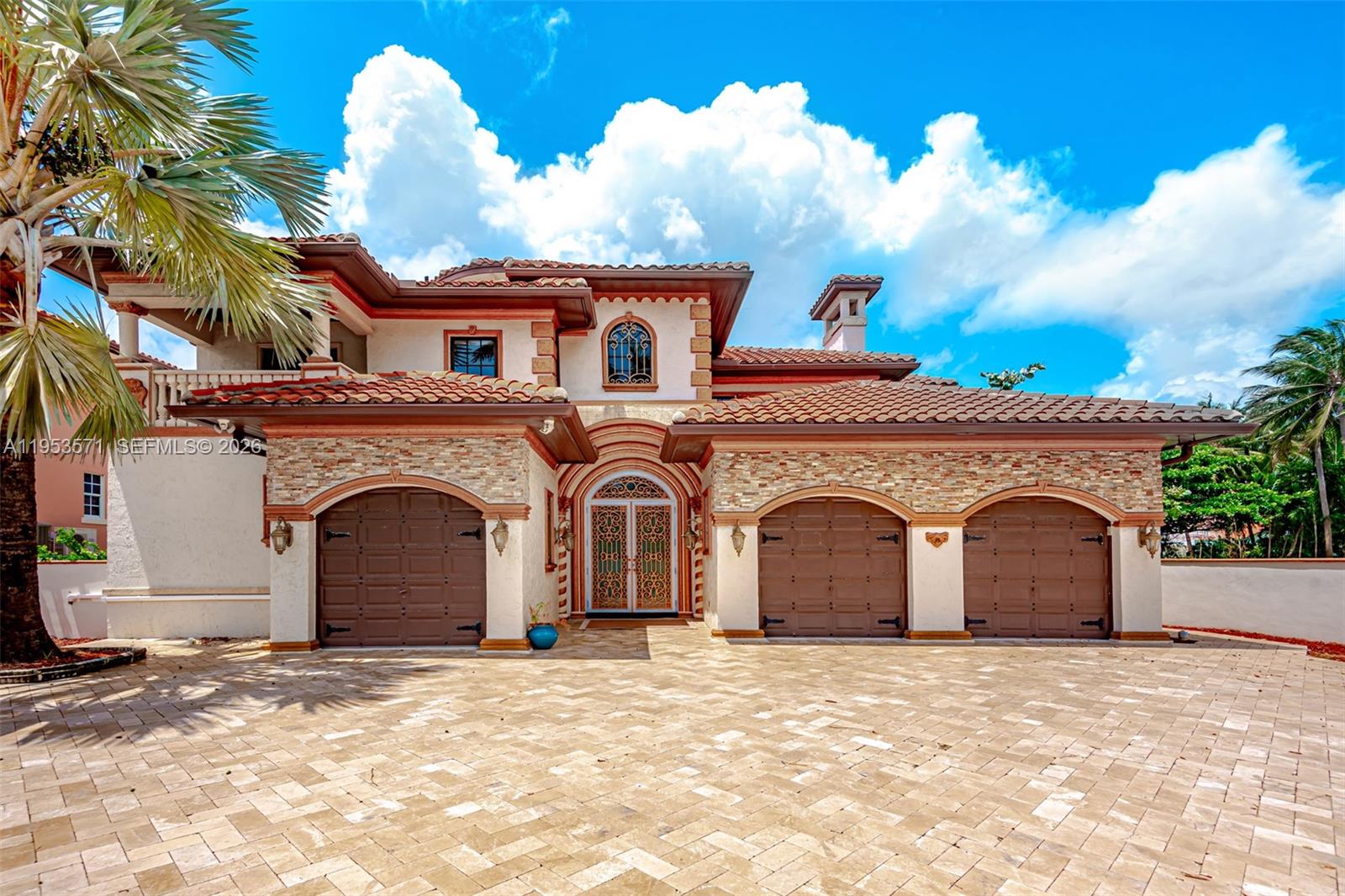 A two-story Mediterranean-style house features a three-car garage and a paved driveway — 674 Ocean Blvd, Golden Beach FL 33160, GOLDEN BEACH, FL