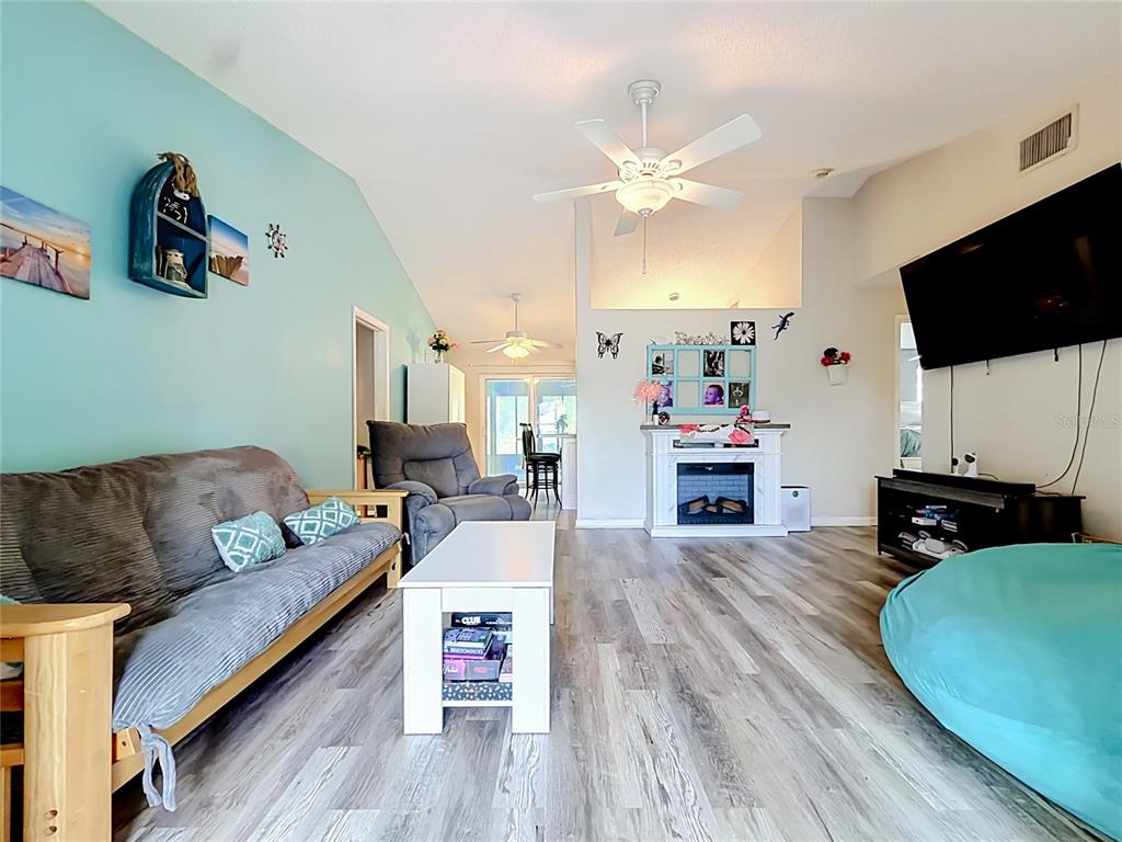 A wooden deck overlooks a pond covered in lily pads under a large tree — 3229 COVINA STREET, NEW PORT RICHEY, FL