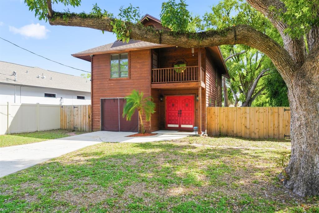 A two-story wooden house features a red double front door and a second-story balcony — 2204 HOWARD LANE, TAMPA, FL