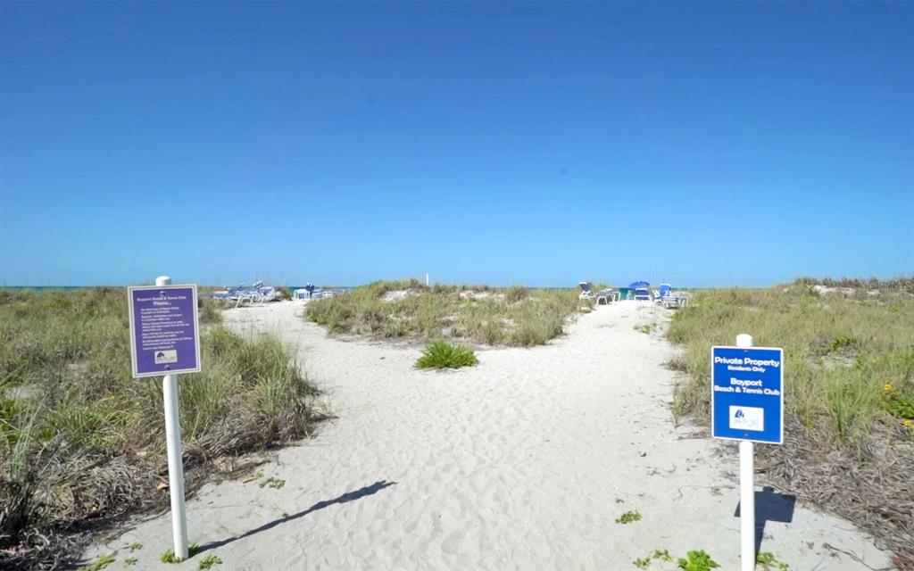 A sandy path leads through dunes toward the ocean at the Bayport Beach & Tennis Club — 750 BAYPORT WAY UNIT 750, LONGBOAT KEY, FL