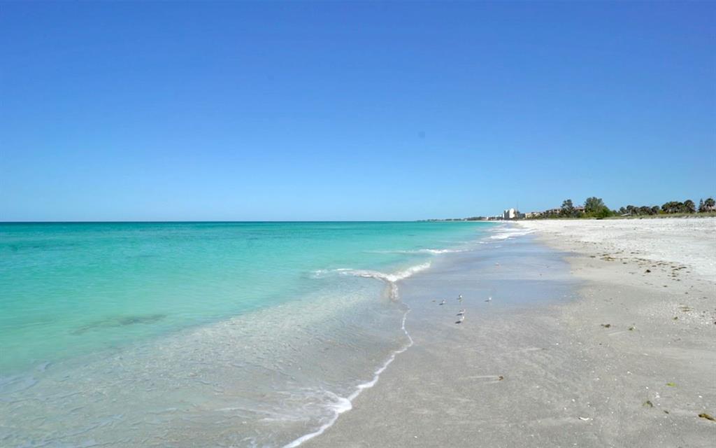 A wide, sandy beach meets turquoise ocean water under a clear blue sky — 750 BAYPORT WAY UNIT 750, LONGBOAT KEY, FL