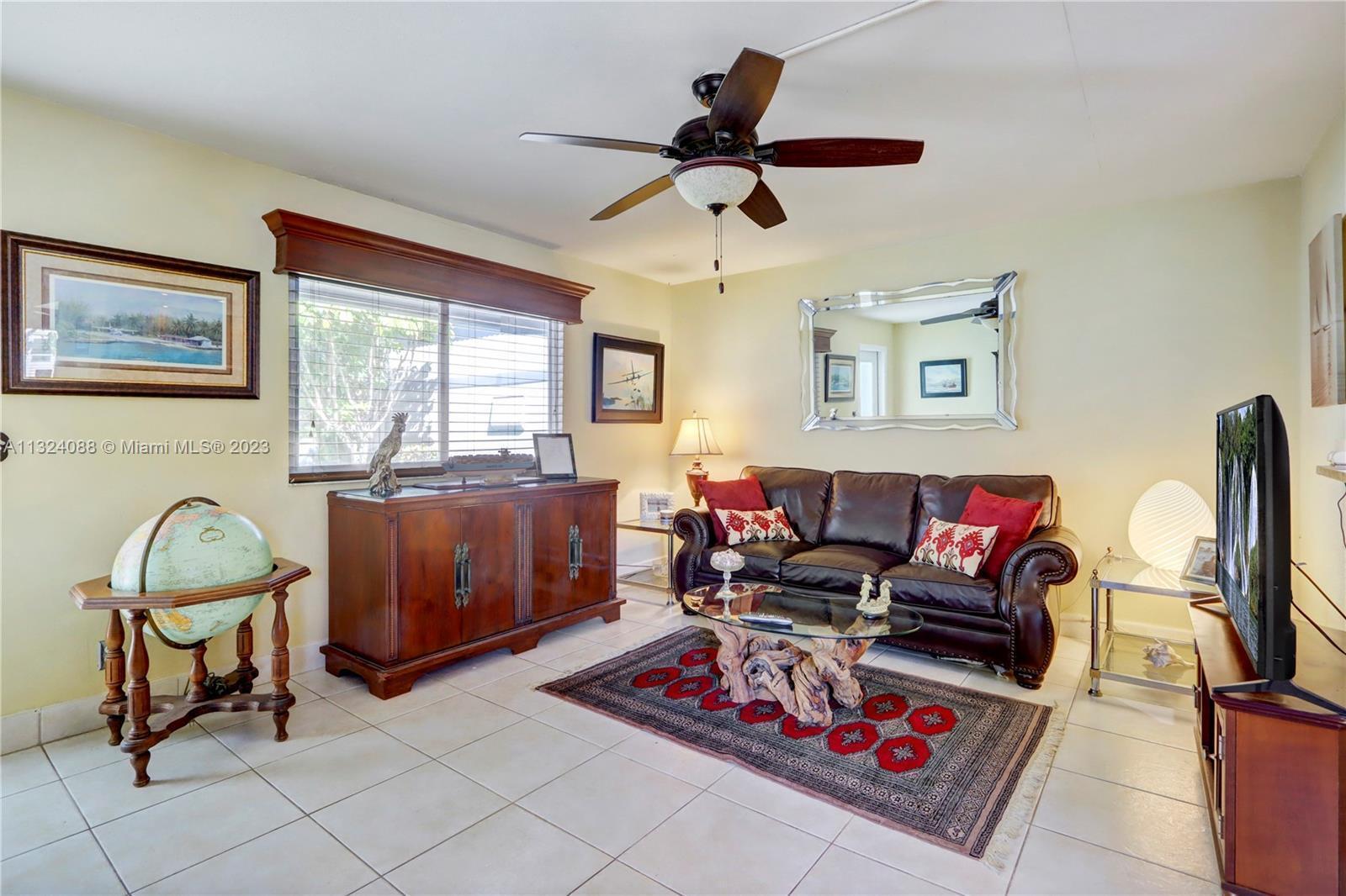 A living room features a leather sofa, a glass coffee table, and a globe — 694 Brittany Park # O, Delray Beach FL 33446, DELRAY BEACH, FL