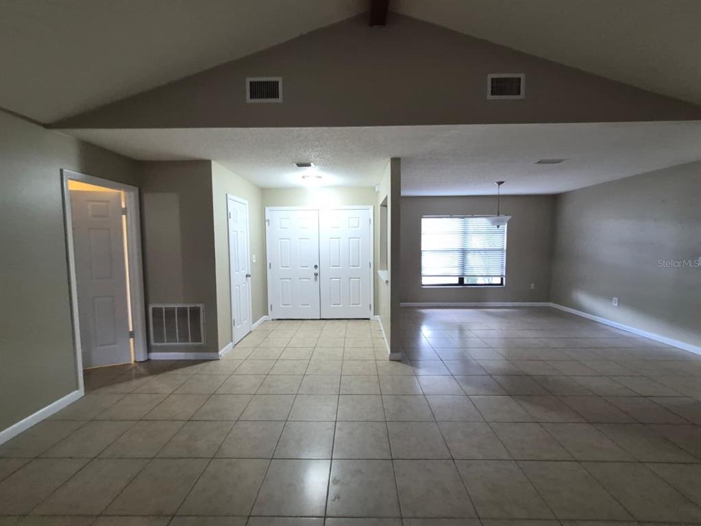 A kitchen features white cabinets, stainless steel appliances, and black countertops over tile flooring — 10227 LANDMARK DRIVE, HUDSON, FL