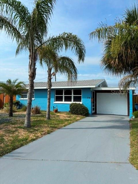 A blue single-story house with a white garage door and palm trees in the front yard — 28 AZALEA DRIVE, ORMOND BEACH, FL