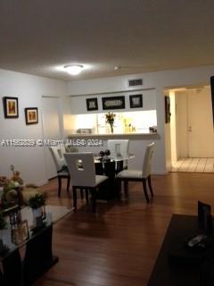 A dining area features a glass-topped table with four white chairs near a kitchen pass-through — 8160 Geneva Ct # 206, Doral FL 33166, DORAL, FL