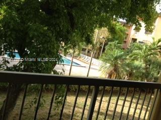 A view from a balcony overlooking a swimming pool, trees, and a multi-story building — 8160 Geneva Ct # 206, Doral FL 33166, DORAL, FL