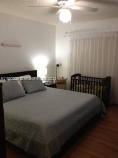 A bedroom features a large bed, a crib, and a ceiling fan with light fixtures — 8160 Geneva Ct # 206, Doral FL 33166, DORAL, FL
