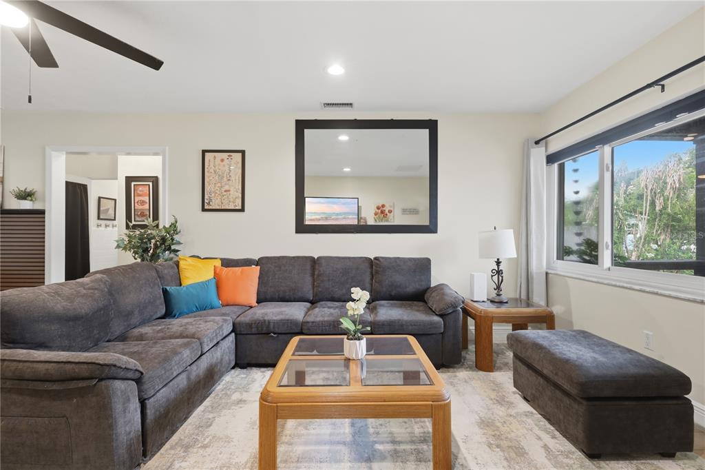 A living room features a large gray sectional sofa, a wooden coffee table, and a mirror — 2341 DEVON COURT, WINTER PARK, FL
