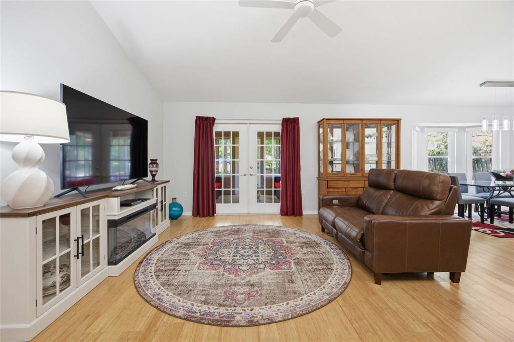 A living room features a brown leather sofa, a television stand, and a round rug — 1106 NW 101ST DRIVE, GAINESVILLE, FL
