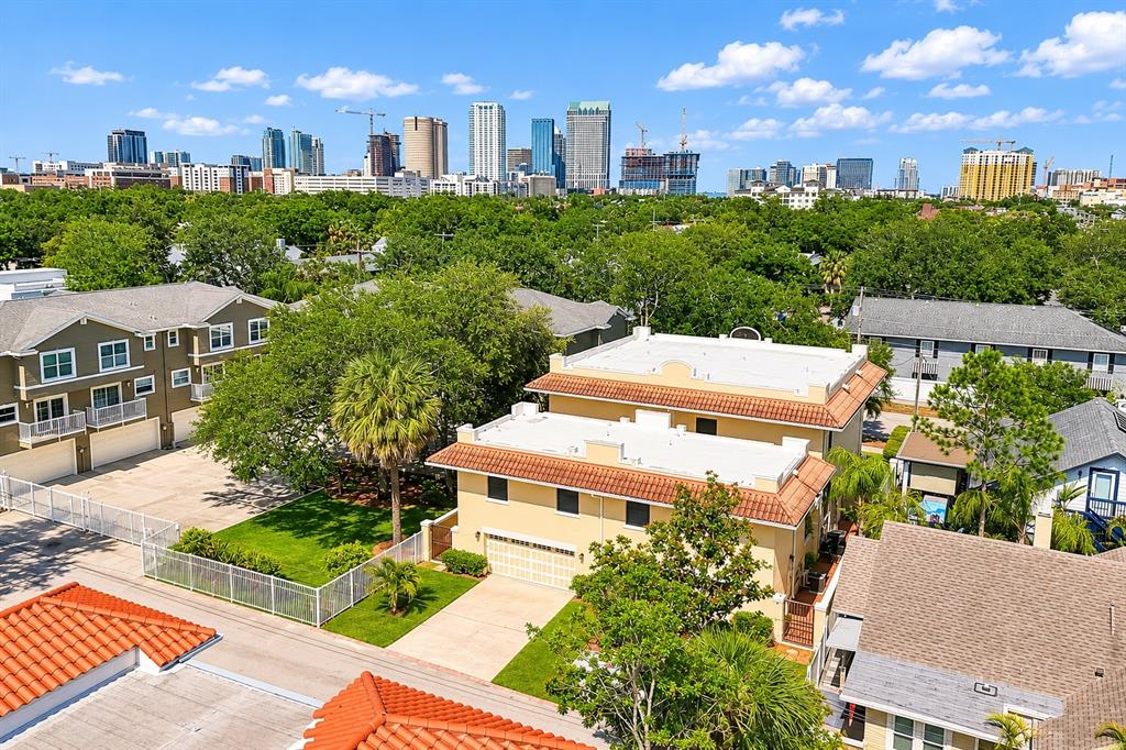 An aerial view shows a yellow two-story house with a tile roof near city buildings — 509 S WILLOW AVENUE UNIT 1, TAMPA, FL
