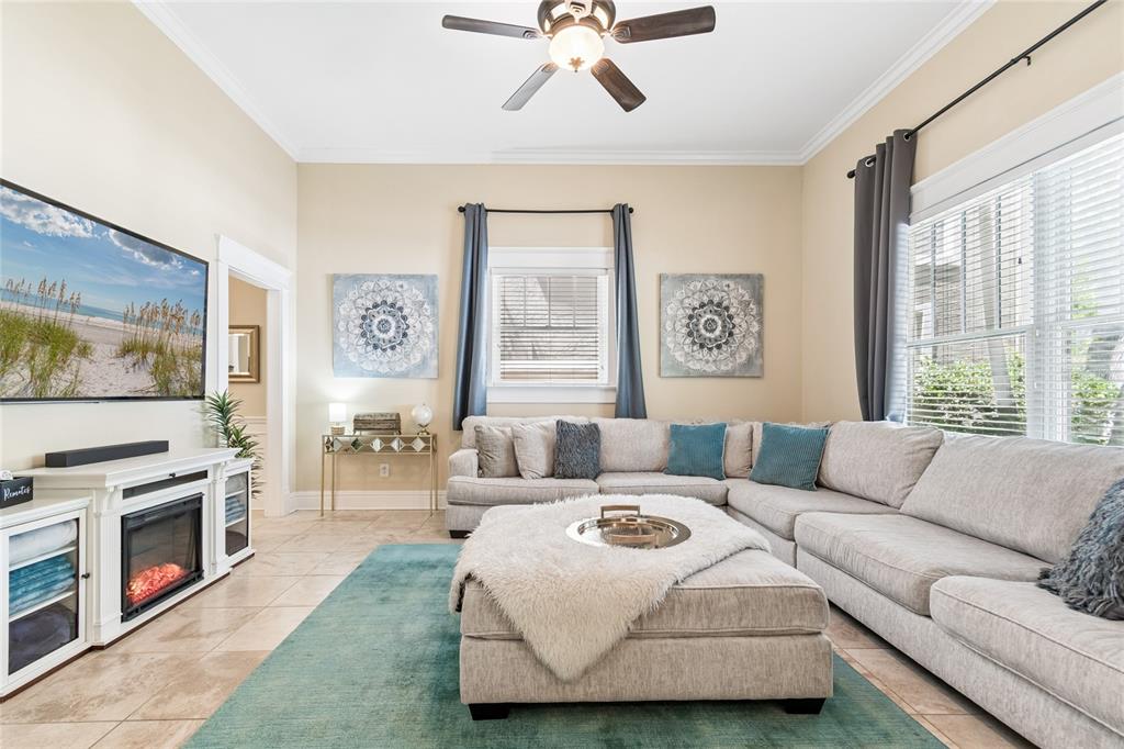 A living room features a large sectional sofa, a fireplace console, and a teal rug — 509 S WILLOW AVENUE UNIT 1, TAMPA, FL