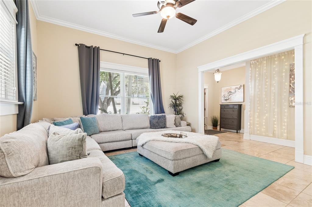 A living room features a large sectional sofa, a central ottoman, and a teal rug — 509 S WILLOW AVENUE UNIT 1, TAMPA, FL