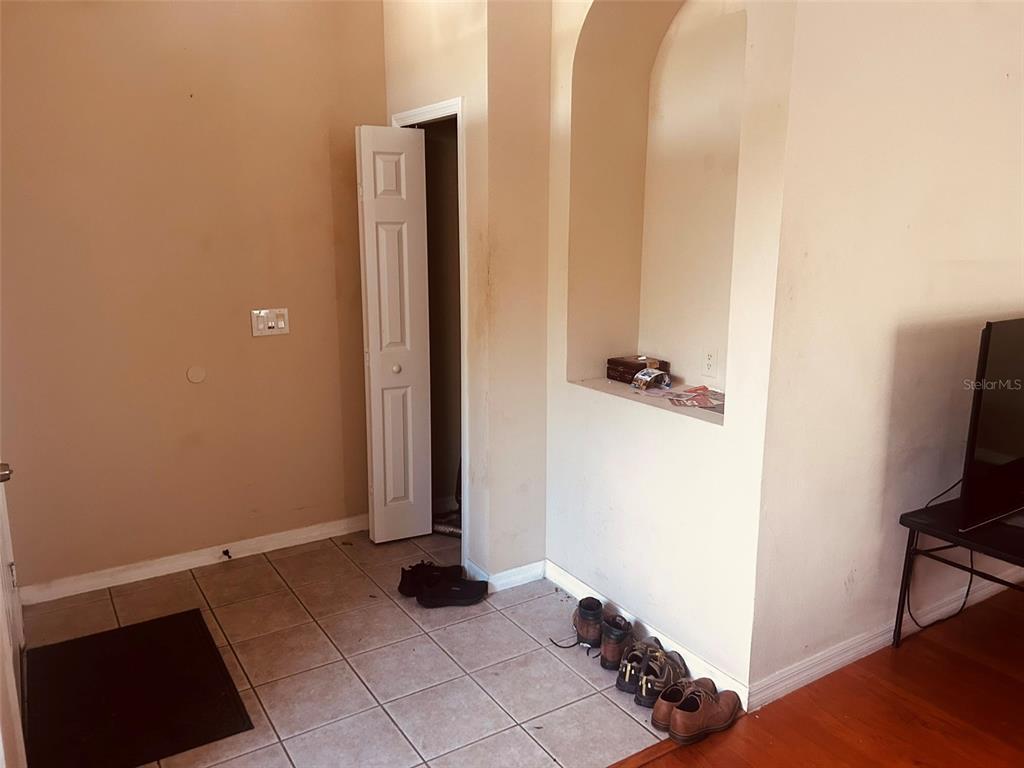 An interior view shows a tiled entryway with a closet door and a recessed wall niche — 9962 BENNINGTON CHASE DRIVE, ORLANDO, FL