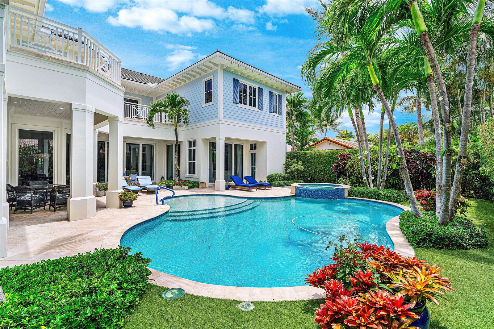 A two-story house with light blue siding features a swimming pool and patio area — 2249 E Maya Palm Drive, Boca Raton FL 33432, BOCA RATON, FL
