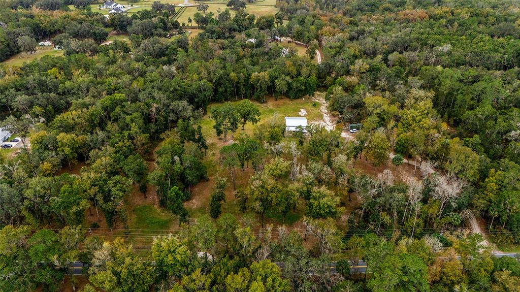 An aerial view shows a house situated on a large, wooded lot with a driveway — 2578 SE 110TH STREET, OCALA, FL