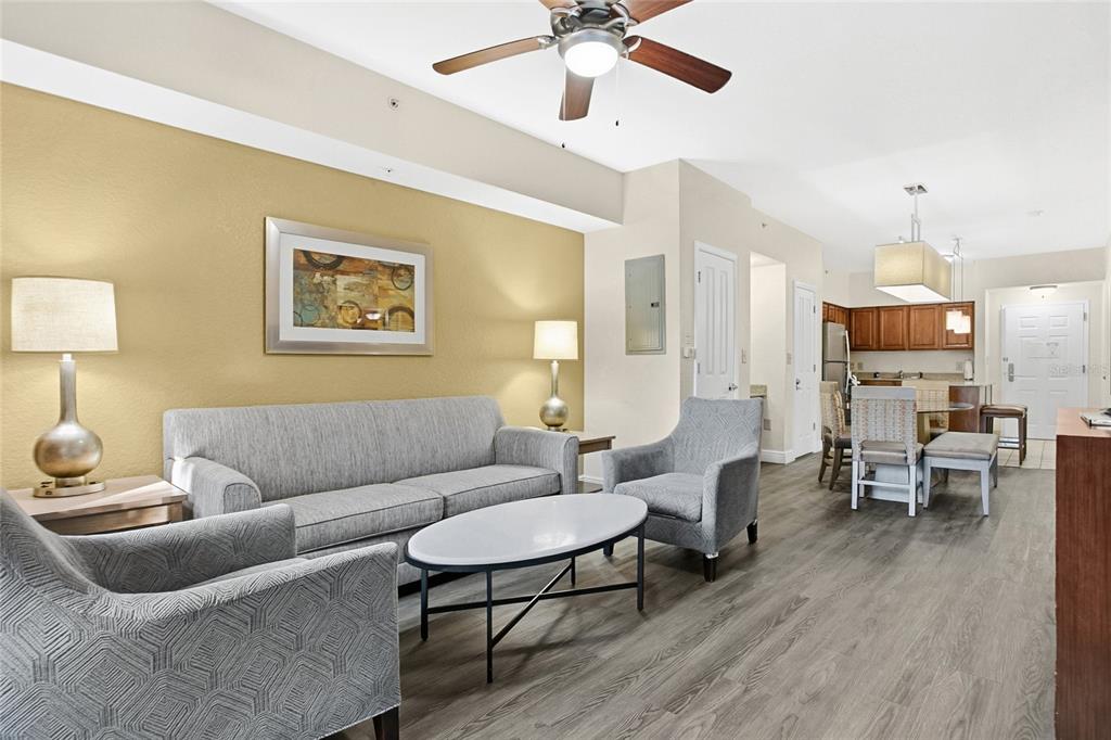A living room with a gray sofa, two armchairs, a coffee table, and wood-look flooring — 12539 FLORIDAYS RESORT DRIVE UNIT 203D, ORLANDO, FL