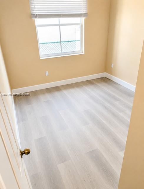 An empty room with light wood-look flooring, beige walls, and a window with white blinds — 5420 SW 134th Ave # 0, Miramar FL 33027, MIRAMAR, FL