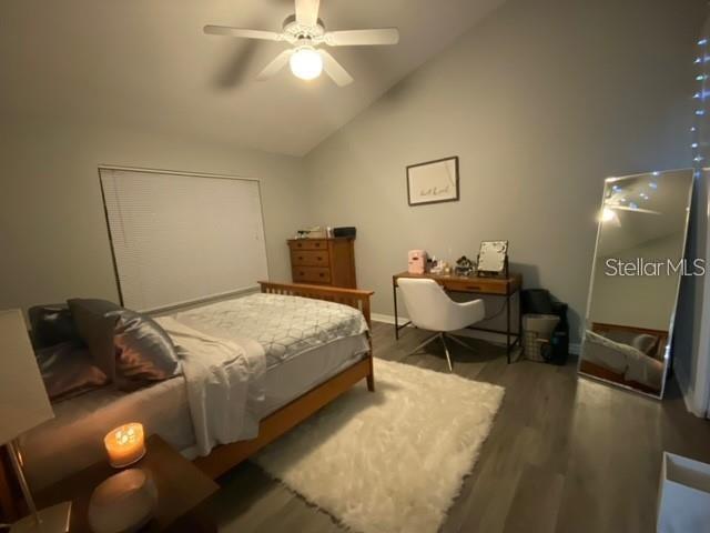 A bedroom features a bed, a desk with a chair, and a full-length floor mirror — 10000 SW 52ND AVENUE UNIT 158, GAINESVILLE, FL