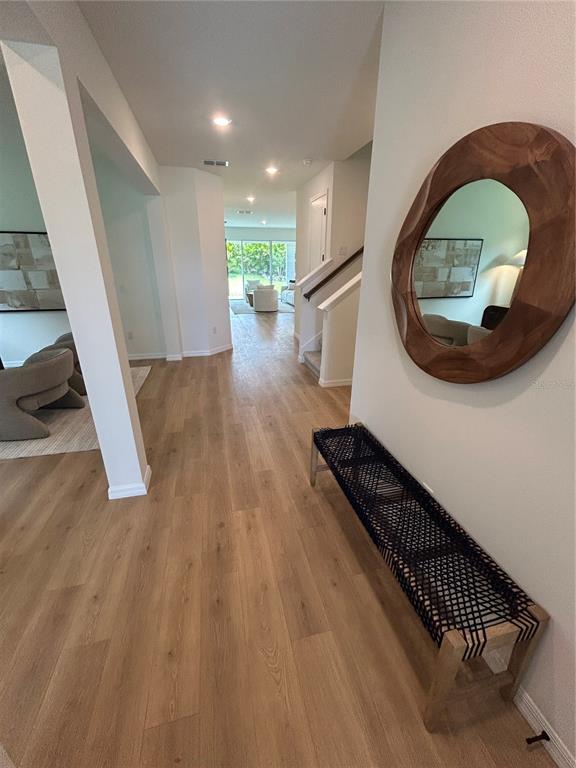 A bright entryway with light wood floors leads to a home office and living area — 5249 EVERLONG DRIVE, APOLLO BEACH, FL