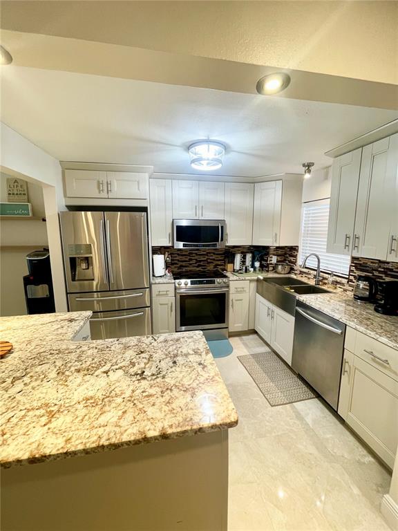 A balcony features a round patio table with four chairs overlooking a waterfront view — 1270 GULF BOULEVARD UNIT 406, CLEARWATER, FL