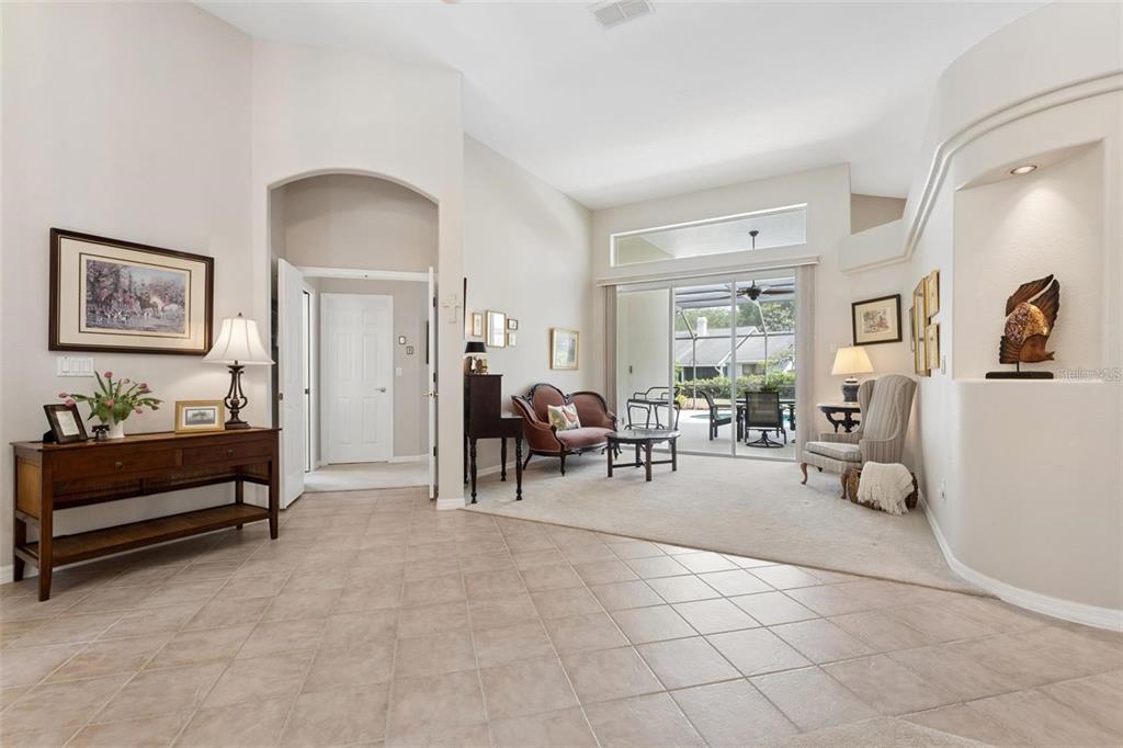 A bright foyer features beige tile flooring, white doors, and a high arched ceiling — 3865 WINDING LAKE CIRCLE, ORLANDO, FL