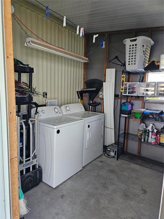 A laundry area with a washer and dryer, metal shelving, and a clothesline in a garage — 375 MELBOURN DRIVE, HAINES CITY, FL