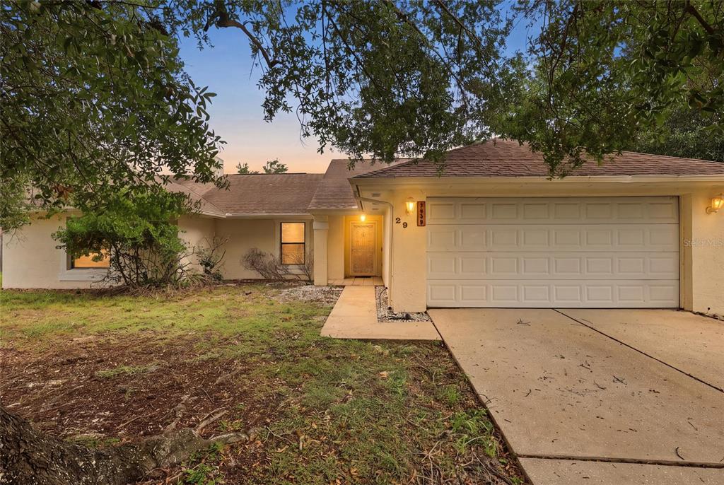 A single-story house with a beige stucco exterior, a two-car garage, and a front walkway — 2939 DANFORTH DRIVE, ORLANDO, FL