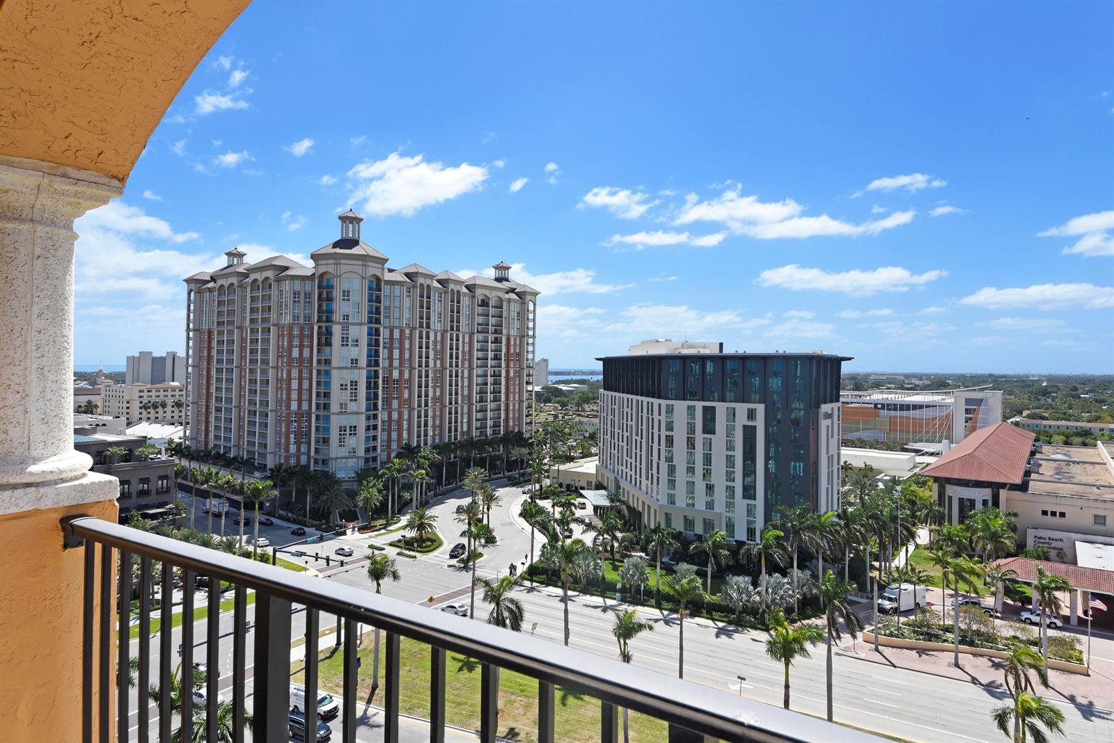 An elevated view from a balcony overlooking city streets, palm trees, and modern buildings — 651 Okeechobee Boulevard # 1209, West Palm Beach FL 33401, WEST PALM BEACH, FL