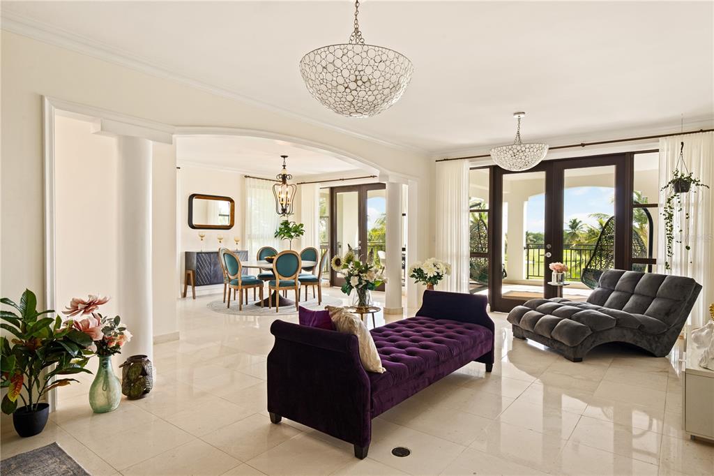 A bright living and dining area features white tile floors, a purple chaise, and chandeliers — 400 COCO BEACH UNIT 301, RIO GRANDE, PR