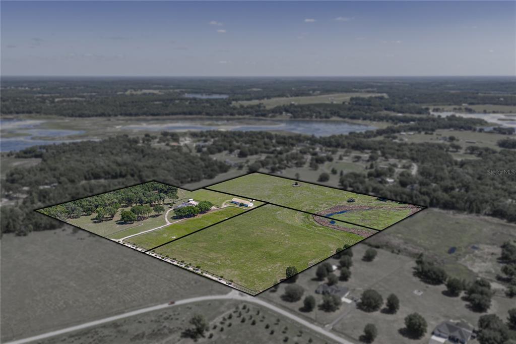 An aerial view shows a large, fenced rural property with buildings and open pasture land — 29001 BAYHEAD ROAD, DADE CITY, FL