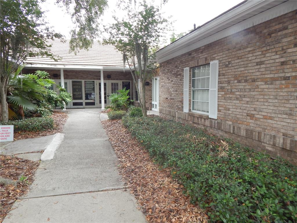 A brick building with a walkway leading to the entrance of a medical center — 705 E OAK STREET UNIT B, KISSIMMEE, FL