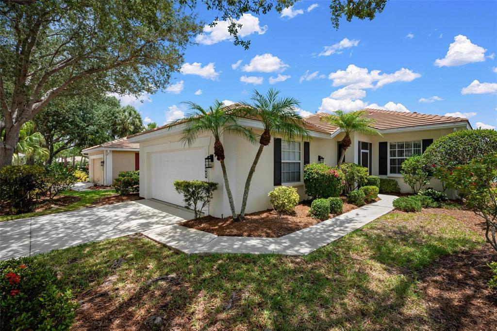 A single-story house with a white stucco exterior, tile roof, and a two-car garage — 880 CHALMERS DRIVE UNIT 880, VENICE, FL