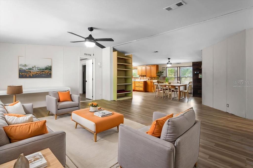 A living room with gray furniture and orange accents flows into an open kitchen area — 173 SW BOUNDARY WAY, FORT WHITE, FL