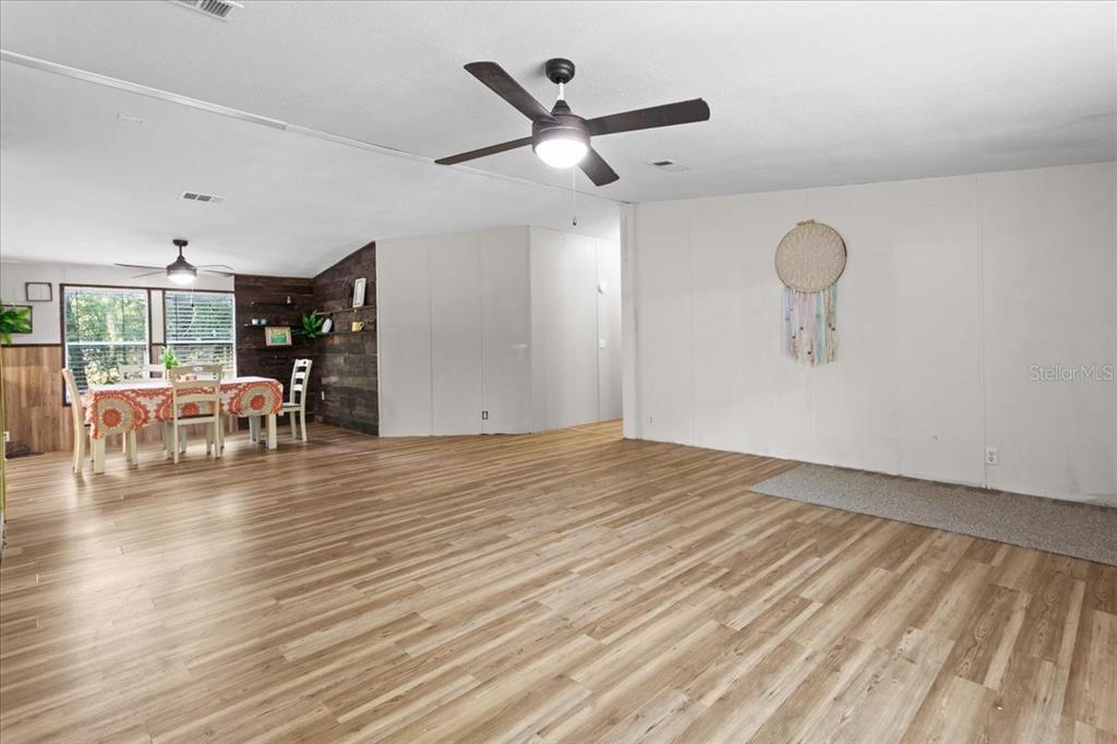 A living room and dining area with wood-look flooring, white walls, and a ceiling fan — 173 SW BOUNDARY WAY, FORT WHITE, FL
