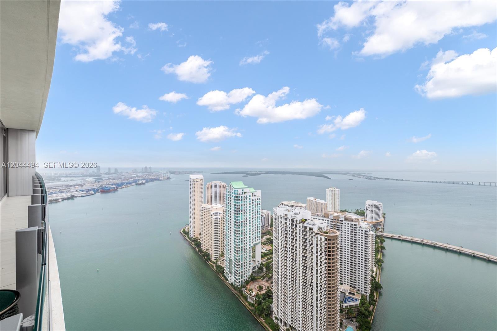 A high-angle view shows a balcony overlooking a peninsula with several tall residential towers — 300 Biscayne Blvd Way # 5104, Miami FL 33131, MIAMI, FL