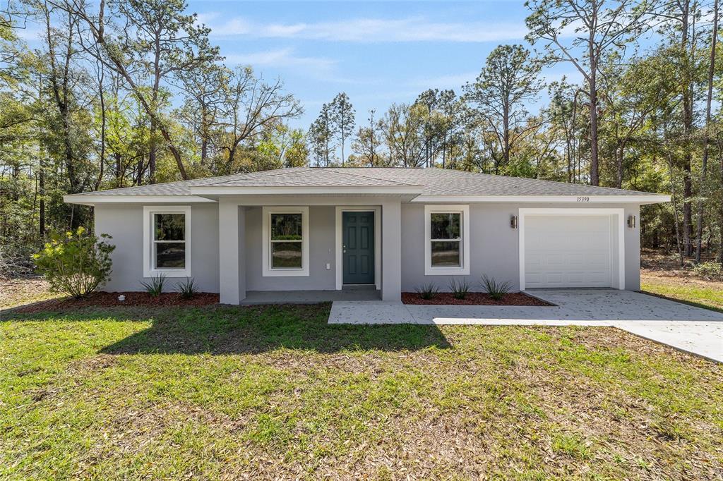 A single-story gray house with a white garage door and a front porch — 15664 SW 28TH LANE, OCALA, FL
