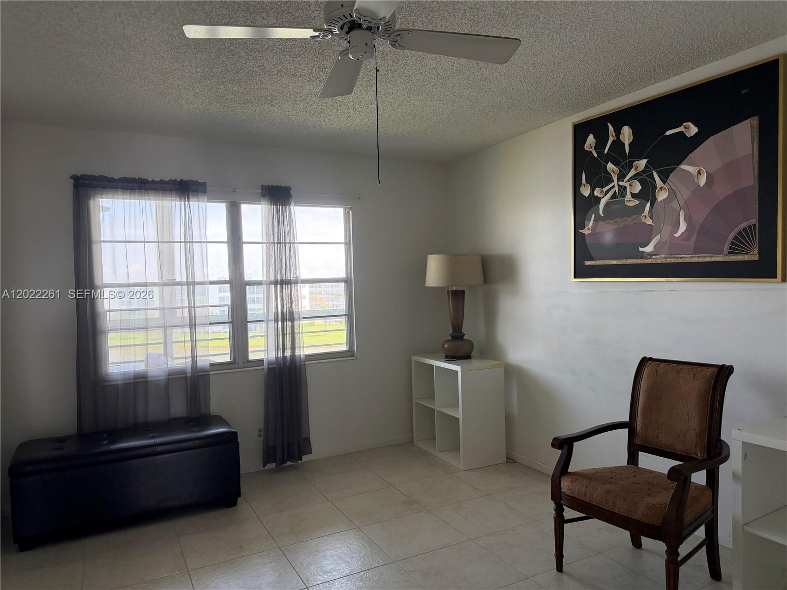 A room with tile floors, a ceiling fan, a window with curtains, and a chair — 4043 Cornwall C # 4043, Boca Raton FL 33434, BOCA RATON, FL
