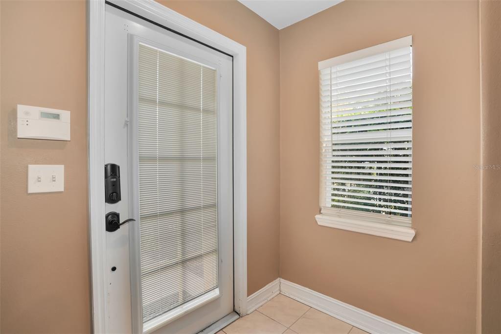 An entryway features a white door with blinds, a window with blinds, and tile flooring — 3102 TOSCANA CIRCLE, TAMPA, FL
