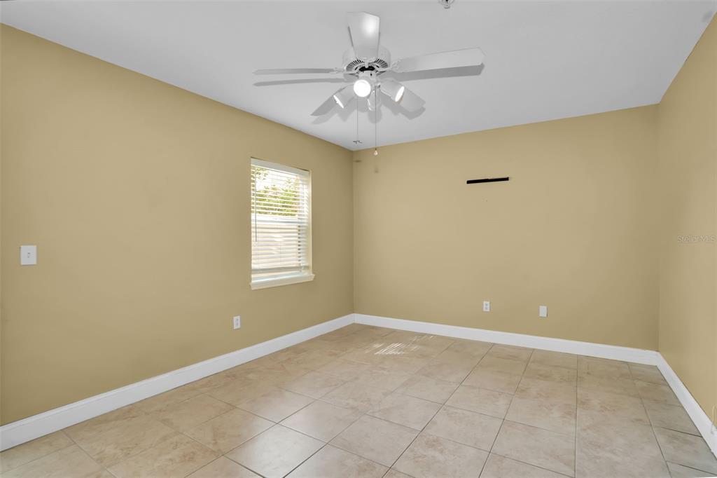 An empty room with tan walls, white trim, a ceiling fan, and tiled flooring — 3102 TOSCANA CIRCLE, TAMPA, FL