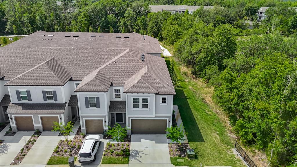 An aerial view shows the exterior of a multi-unit townhouse building with attached garages — 10801 FORT WHITE COURT, TAMPA, FL