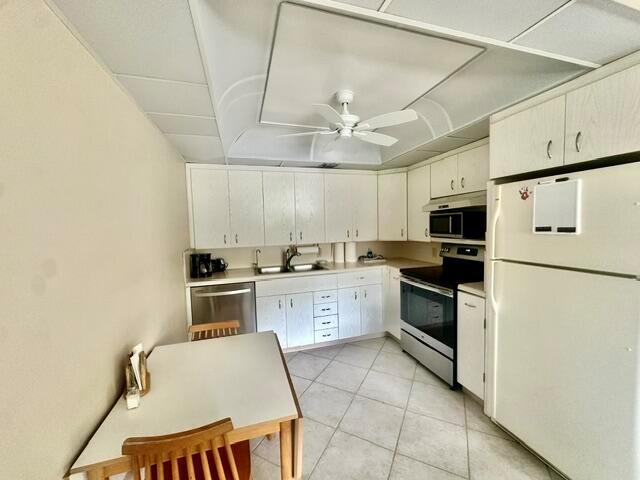 A kitchen features white cabinets, a dining table, and a ceiling fan — 3018 Ainslie B, Boca Raton FL 33434, BOCA RATON, FL