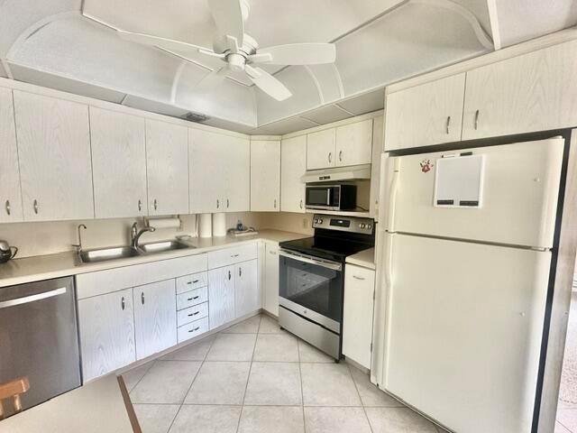 A kitchen features white cabinets, a stainless steel stove, and a white refrigerator — 3018 Ainslie B, Boca Raton FL 33434, BOCA RATON, FL
