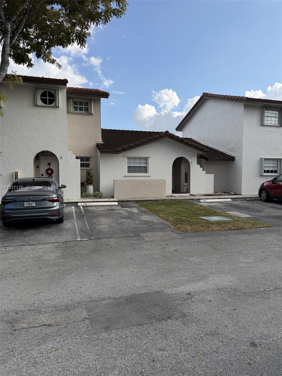 A two-story residential building exterior features white stucco walls, brown tile roofs, and parking spaces — 13551 SW 62nd St # 4 # 155, Miami FL 33183, MIAMI, FL