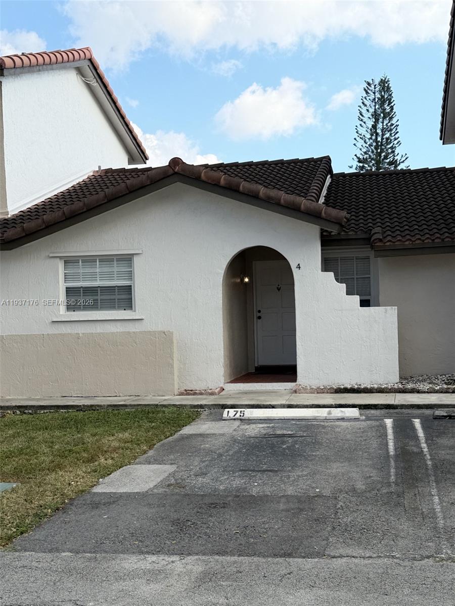 A white exterior home features a brown tiled roof, an arched entryway, and parking space — 13551 SW 62nd St # 4 # 155, Miami FL 33183, MIAMI, FL