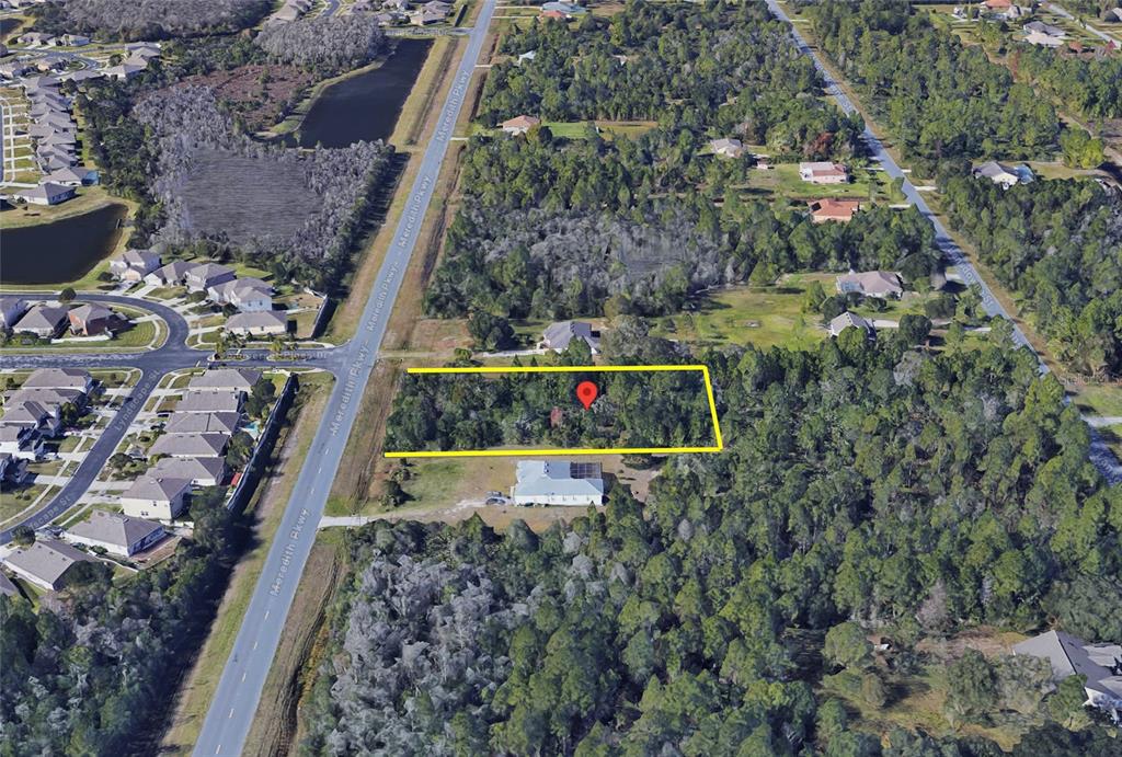 An aerial view shows a rectangular plot of land outlined in yellow near a road — 0 MEREDITH PARKWAY, ORLANDO, FL