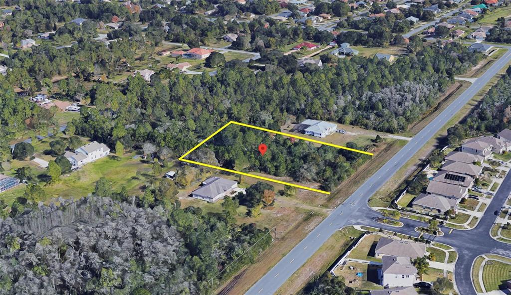 An aerial view shows a rectangular, tree-covered vacant lot outlined in yellow near a road — 0 MEREDITH PARKWAY, ORLANDO, FL